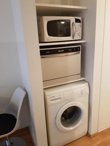 a microwave and a washing machine in a room at Rotermanni Guest Apartments in Tallinn