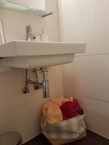 a bathroom with a sink and a pile of towels at Rotermanni Guest Apartments in Tallinn