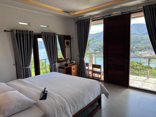 a bedroom with a bed and a large window at Toba Crest Vue in Parapat