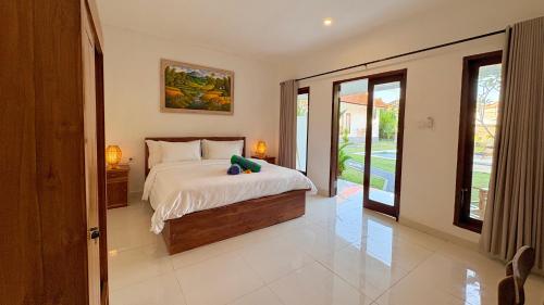 a bedroom with a bed with a stuffed animal on it at ANANDA Bingin Guesthouse in Bingin Beach