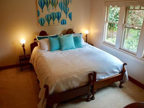 a bedroom with a large bed with blue pillows at Manderley Park Farmstay B&B in Buln Buln
