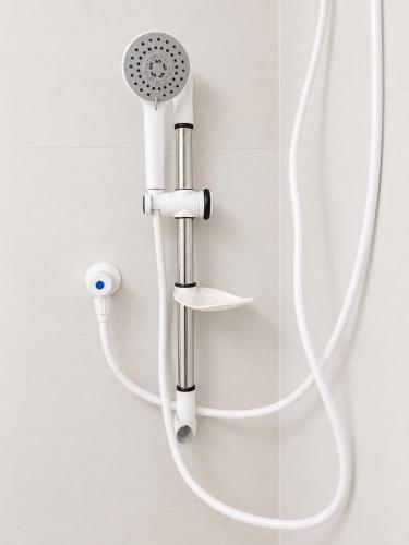 a shower with a white hose attached to a wall at The Blue Sapphire Of Wilpattu in Wilpattu
