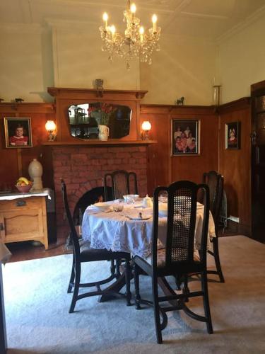 a dining room with a table and chairs and a fireplace at Manderley Park Farmstay B&B in Buln Buln