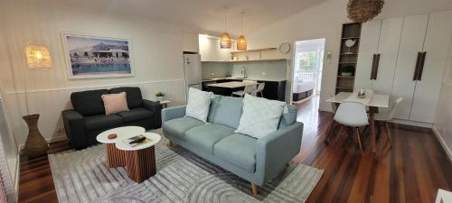 a living room with a blue couch and a kitchen at South Pacific Resort & Spa Noosa in Noosaville