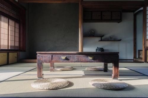 a room with a wooden table and some baskets on the floor at Omoya Kitahata in Karatsu