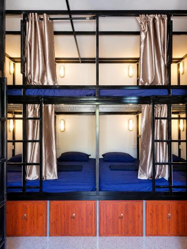 two bunk beds in a room with blue sheets at Blue Zone Hostel in Kaôh Rŭng (3)