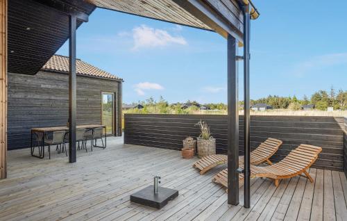 a patio with a table and chairs on a wooden deck at Stunning Home In Jerup With Sauna in Jerup