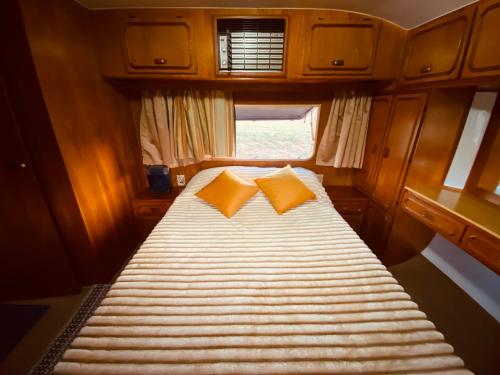 a bed with two pillows in a small room at Tiny house móvel com vista 360 in São Roque