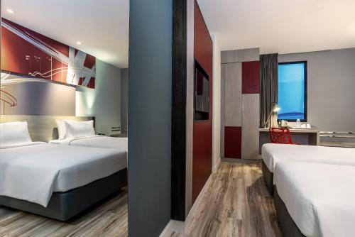 a hotel room with two beds and a desk at ibis Bangkok IMPACT in Nonthaburi