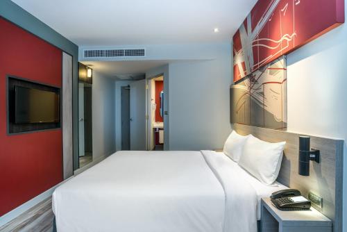a bedroom with a white bed and a tv at ibis Bangkok IMPACT in Nonthaburi