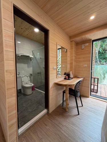 a bathroom with a wooden table and a toilet at 木木杉民宿 in Puli