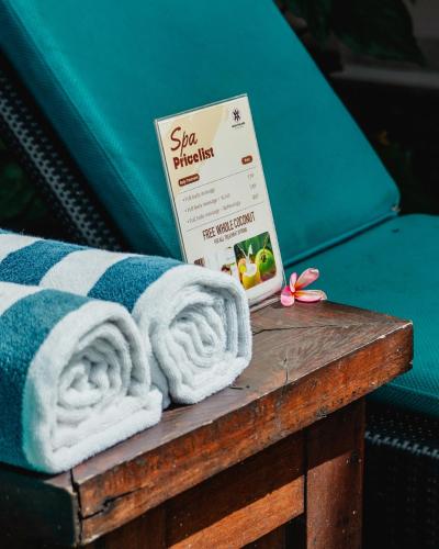 a pile of towels sitting on top of a wooden table at Mina Pelasa Hotel in Legian