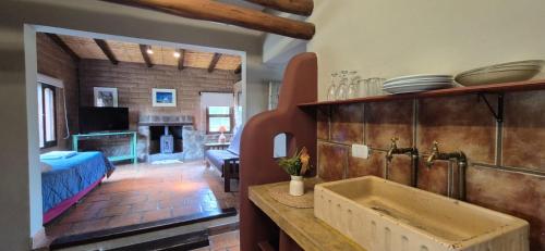 a kitchen with a sink and a living room at Miraluna - Cabañas & Bodega in Cachí