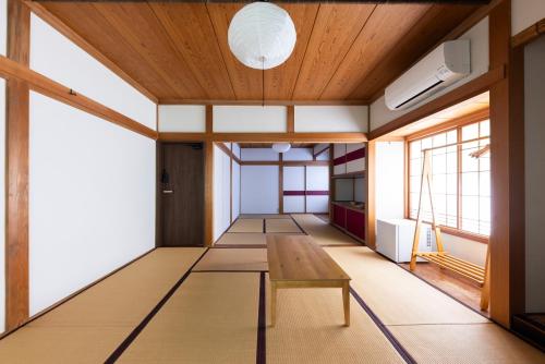 an empty room with a table and windows at 鈴木旅館 in Joetsu