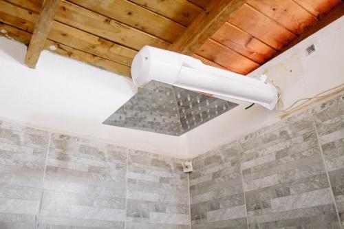 a ceiling light in a bathroom with a stone wall at Aparta estudio in Itagüí