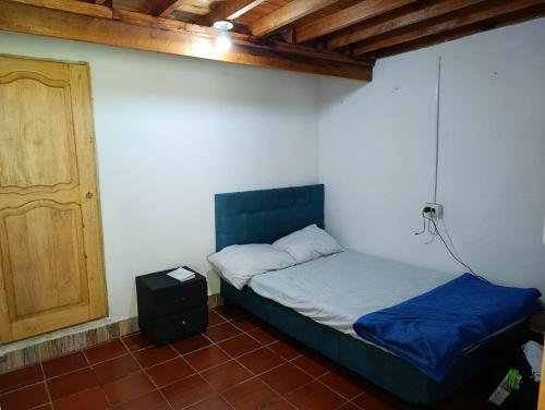 a bedroom with a bed and a wooden door at Finca de las banderas in Jardin