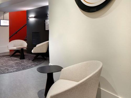 a waiting room with a chair and a stool at Mercure Montpellier Centre Comédie in Montpellier