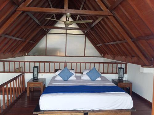 a bedroom with a large bed with blue pillows at Amed Santorini Villa in Amed