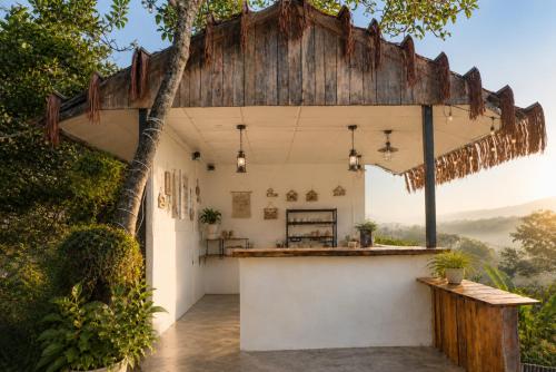 an outdoor kitchen with a wooden pergola at THỎ NON GARDEN CLOUDY OCEAN VIEW in Blao Srê