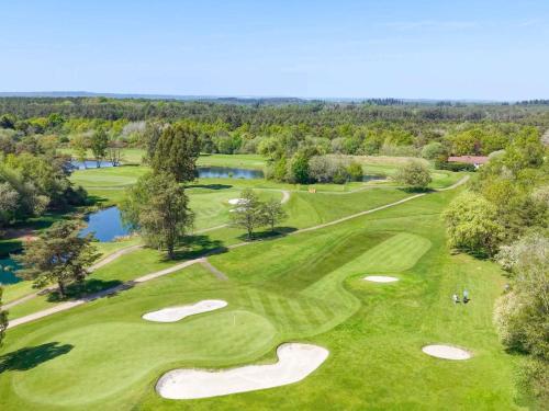 an overhead view of a golf course with a river and trees at Old Thorns Golf Resort And Spa Hampshire by Accor in Liphook