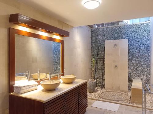 a bathroom with three sinks and a large mirror at Amed Santorini Villa in Amed
