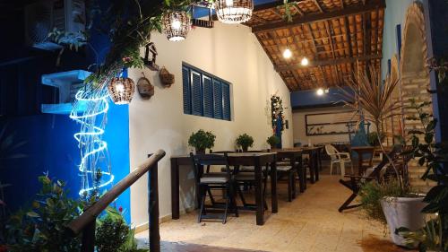 a restaurant with tables and chairs and a blue wall at Pousada Rosa dos Ventos in Genipabu
