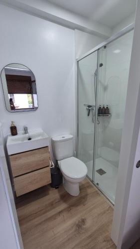 a bathroom with a toilet and a glass shower at Casa Adrianykenia in San Martín de Laspra