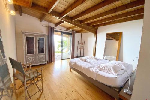 a bedroom with a bed and a chair in it at Villa TheOceane in Les Avirons