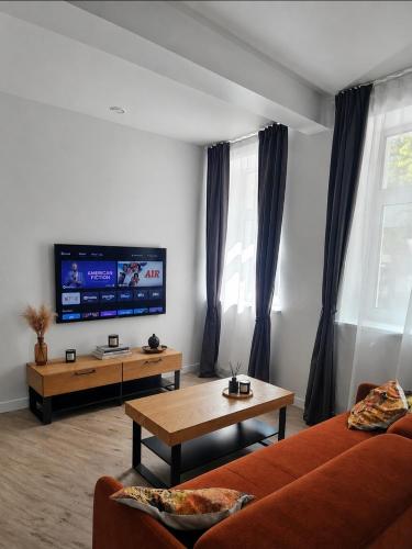a living room with a couch and a tv at Mažvydo Alėjos Self Check-In in Klaipėda