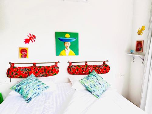 a bedroom with a white bed with red pillows at VILLA 3 CHAMBRES a partager in Nathon Bay