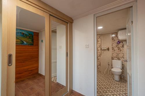 a bathroom with a toilet and a glass door at Villa Darma Ubud by Bali Cabin in Ubud