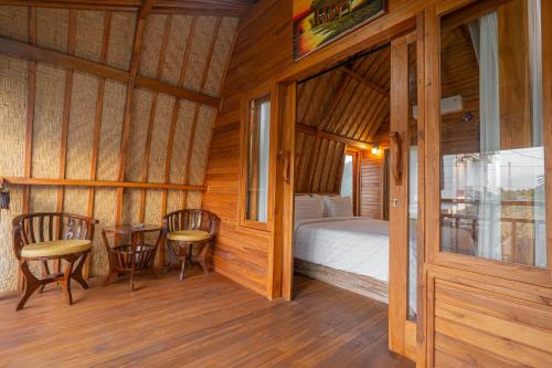 a bedroom with a bed and a table and chairs at Villa Darma Ubud by Bali Cabin in Ubud