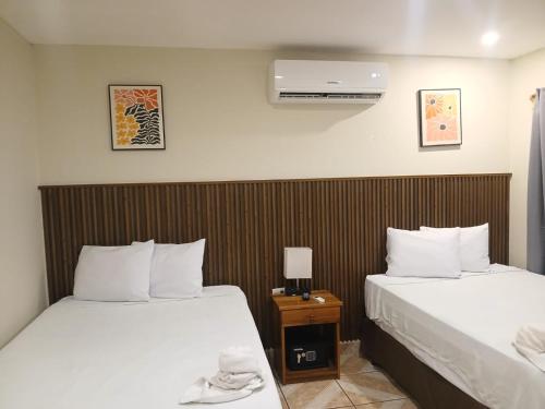 a hotel room with two beds and a air conditioner at Hotel Miraflores in El Cuco