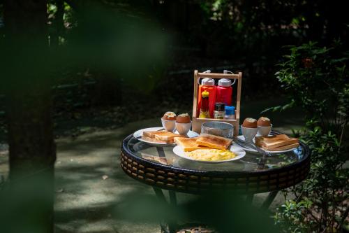 a table with food and bread on top of it at Akchanok Homestay - Nature Retreat in Phitsanulok