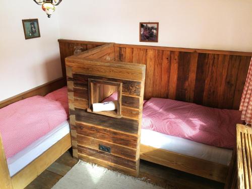 1 Schlafzimmer mit 2 Einzelbetten und einer Holzwand in der Unterkunft Romantikzimmer Jakobbauer in Turnau