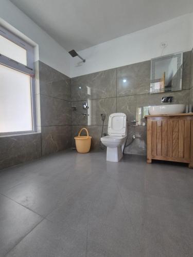 a bathroom with a toilet and a sink at Hunder Nature Retreat in Hundar