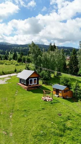 an aerial view of a house in a field at Cabana Vatra Plaiului in Şarul Dornei