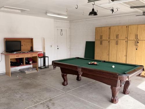 a room with a pool table and a tv at Suitewater in Peoria