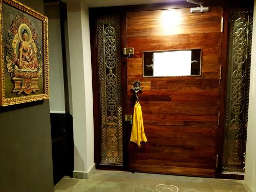 a wooden door in a room with a yellow dress on it at Utse Suites in Bengaluru
