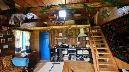 a kitchen and living room in a log cabin at Cabana Vatra Plaiului in Şarul Dornei