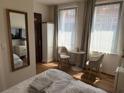 una camera da letto con uno specchio, un tavolo e delle sedie di Süd5 a Borkum