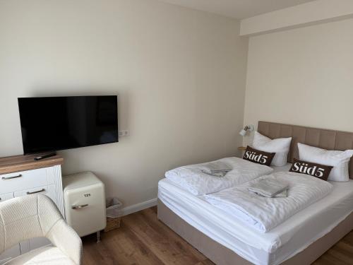 una camera da letto con un letto e una TV a schermo piatto di Süd5 a Borkum