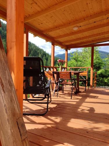 a wooden porch with a table and chairs on it at Шале над скелею in Krivorovnya