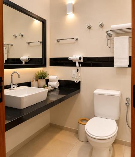a bathroom with a sink and a toilet and a mirror at Ilha Flat Apto 3207 in Ilhabela