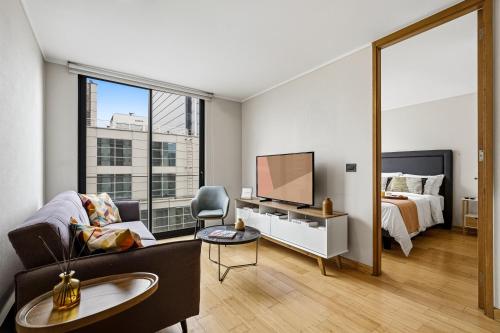 a living room with a bed and a tv and a bedroom at Nest Collection El Golf in Santiago