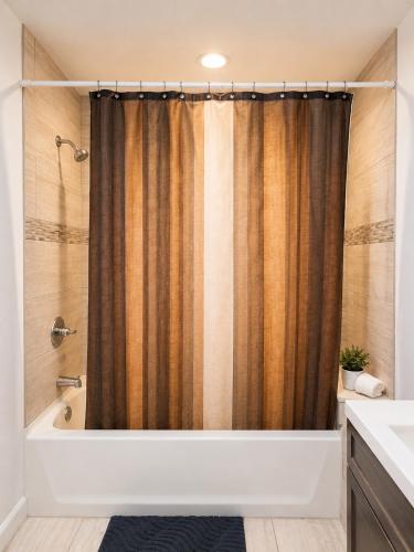 a bathroom with a tub and a shower curtain at Stay by Gina in Irvington