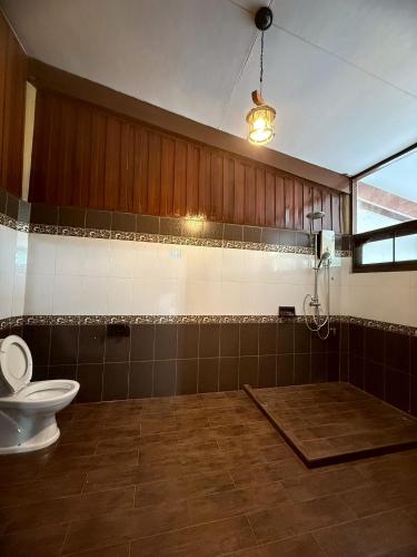 a bathroom with a toilet and a light on the ceiling at Bann Maii Soi 14 in Ban Hua Khao Sammuk