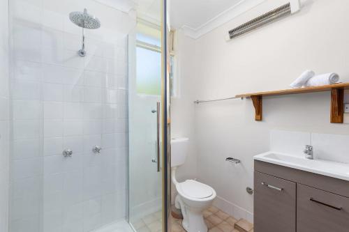 a bathroom with a shower and a toilet and a sink at Rock On in Jindabyne
