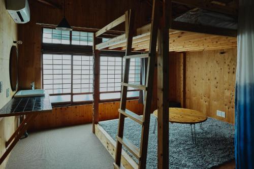 a room with two bunk beds and a table at まちの別邸 緝 shu in Kochi