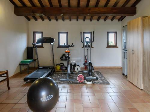 a room with a gym with a treadmill and exercise equipment at Flat on a farm with swimming pool and many activities in SantʼAngelo in Vado